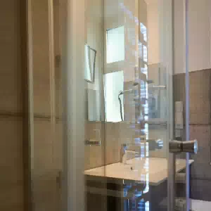 renovierung-bad-2-sanierung-berlin 24 Duschglas aus ESG Glas mit Spiegelung des beleuchteten Heizkörpers